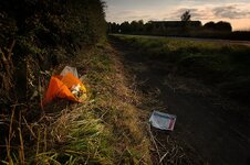 Aftermath of a motorcycle accident. A wrapper from a defibrilation system and some flowers..jpg